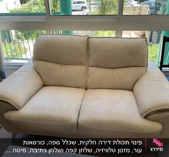 ספה בהירה ליד חלון עם וילון
